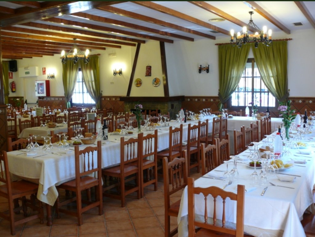 Salón tradicional con chimenea de leña y artesonado en Venta El Túnel